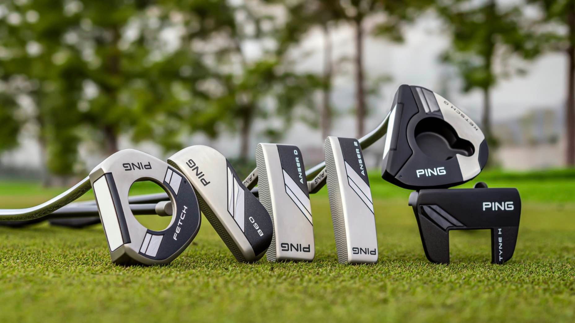 Several putters from the 2024 Ping putter line arranged on a golf course