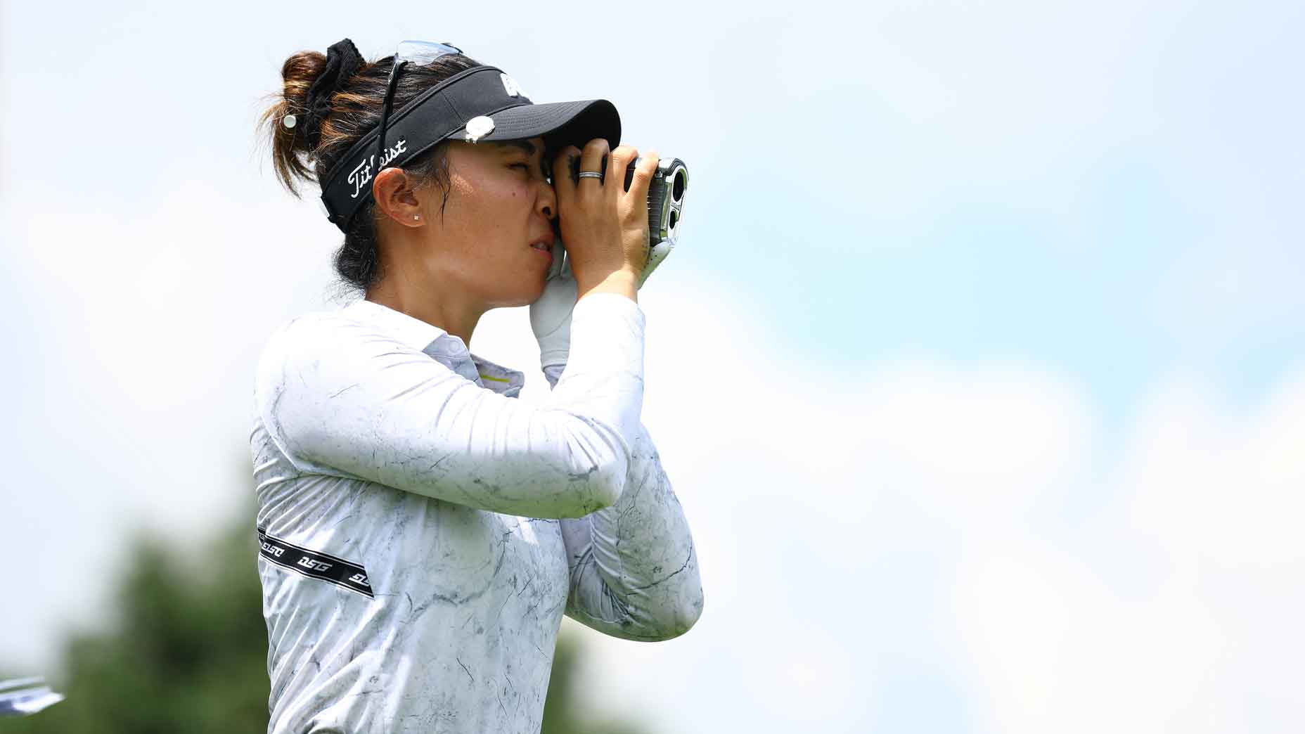 Danielle Kang of the United States looks through her rangefinder as she prepares to tee off on the 16th hole during the first round of the Maybank Championship at Kuala Lumpur Golf and Country Club on October 26, 2023 in Kuala Lumpur, Malaysia.