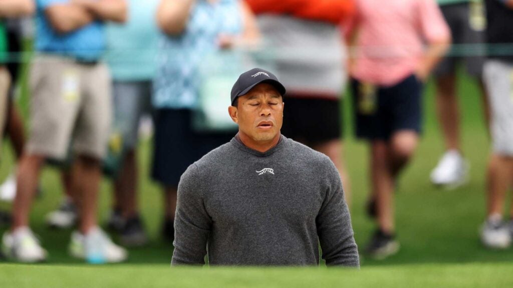 Tiger Woods exhales while standing in a bunker at the Masters.