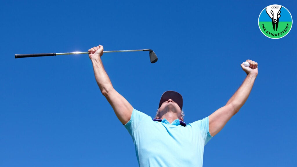 A golfer celebrating with arms raised
