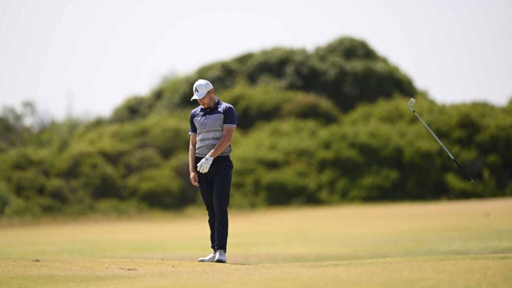 Golfer hangs head on golf green