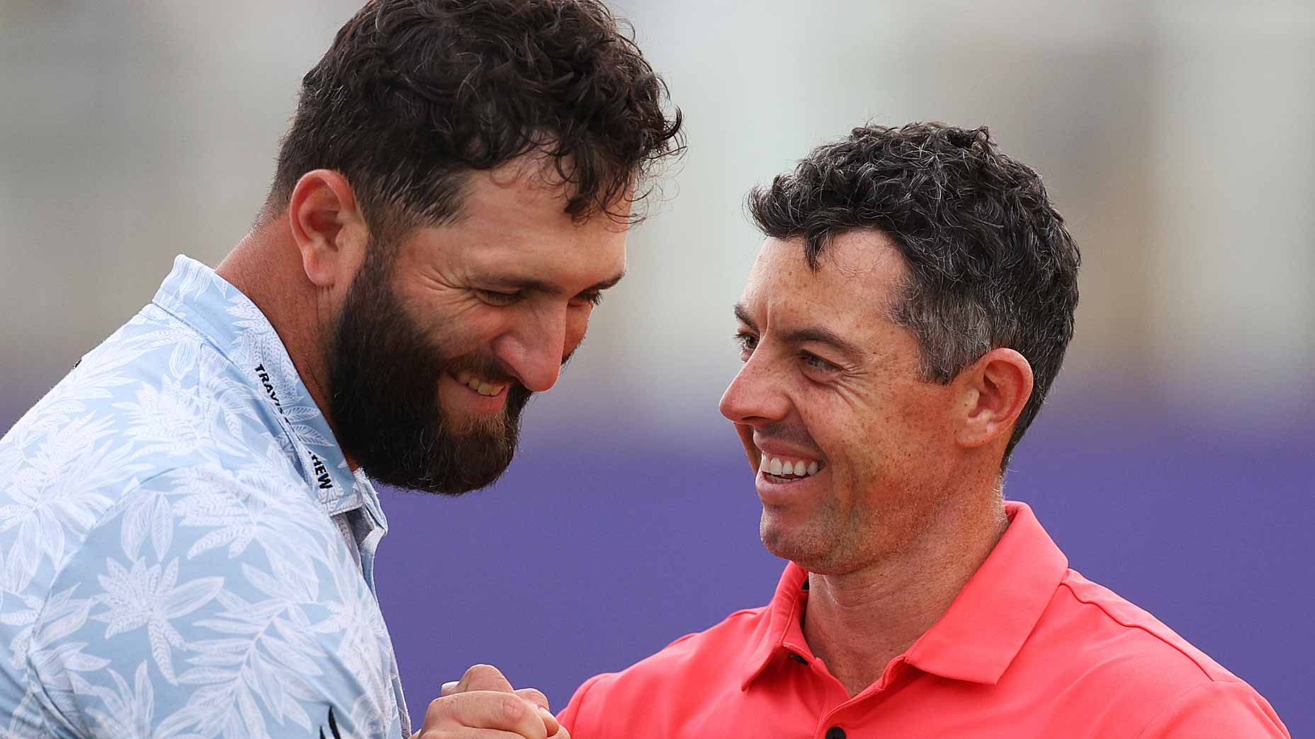 Jon Rahm and Rory McIlroy embrace at the 2023 DP World Tour Championship.