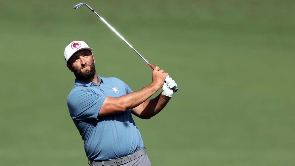 Jon Rahm hits a wedge during a Masters practice round.
