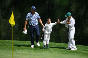 Gary Woodland and his son, Jaxson, celebrate as he makes a putt on the ninth hole
