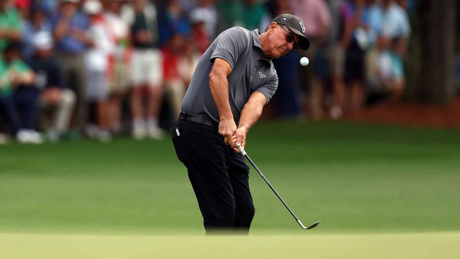 phil mickelson hits a chip shot next to a green