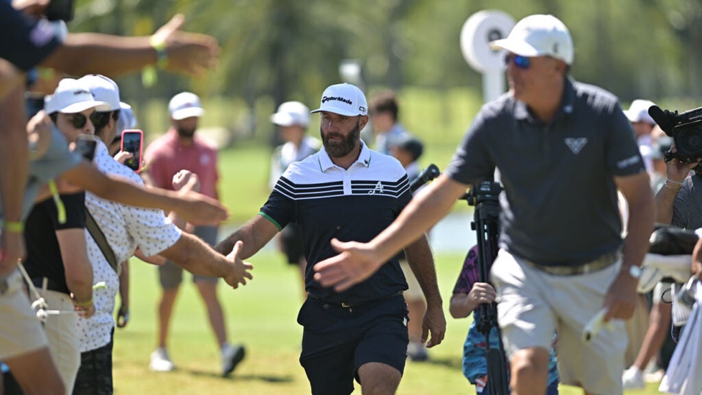 Dustin Johnson, left, and Phil Mickelson shake hands with fans, during, LIV Golf Miami