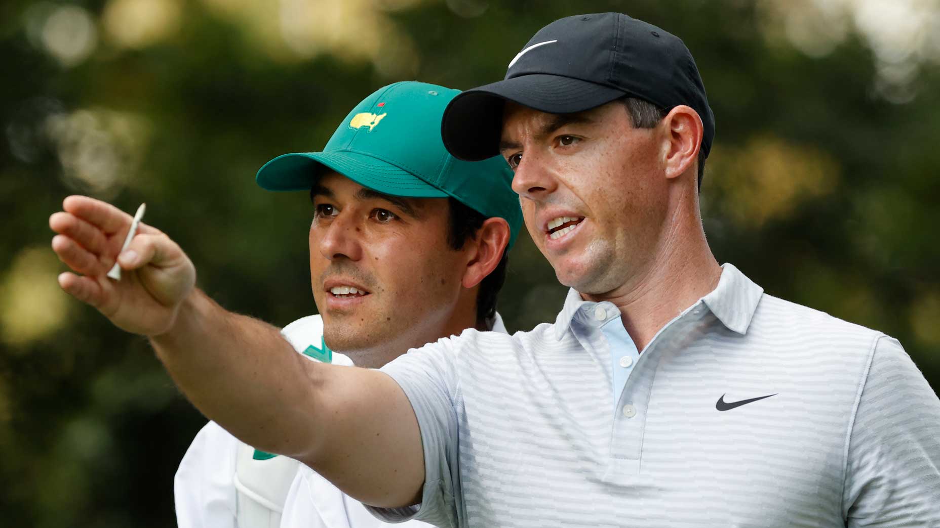 Rory McIlroy and his caddie point down fairway at 2020 Masters