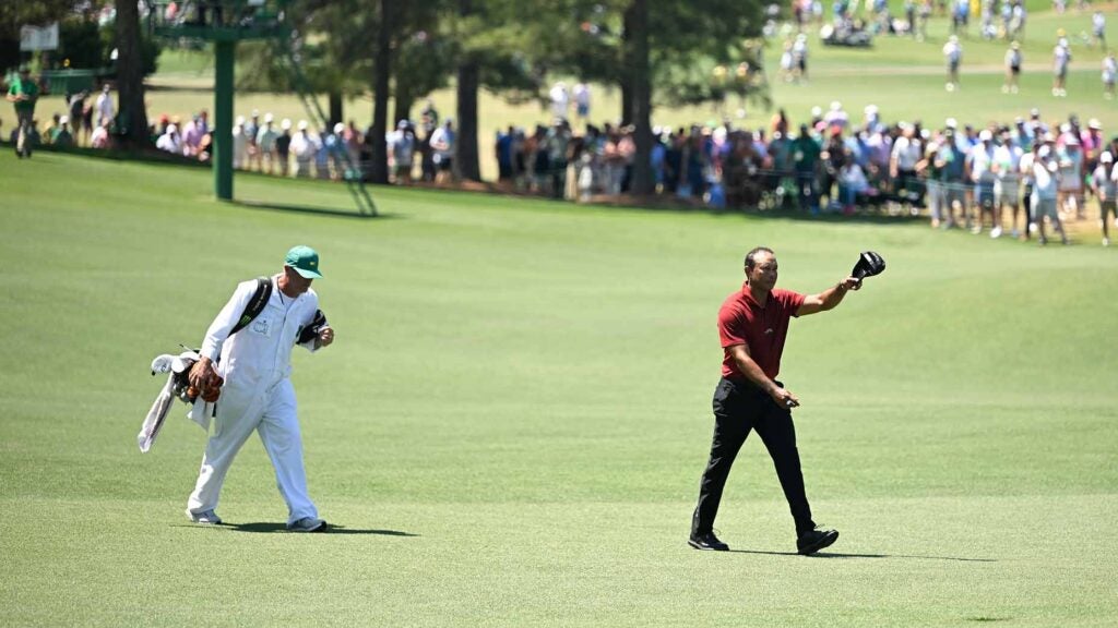 tiger woods walks up the 18th fairway at the masters