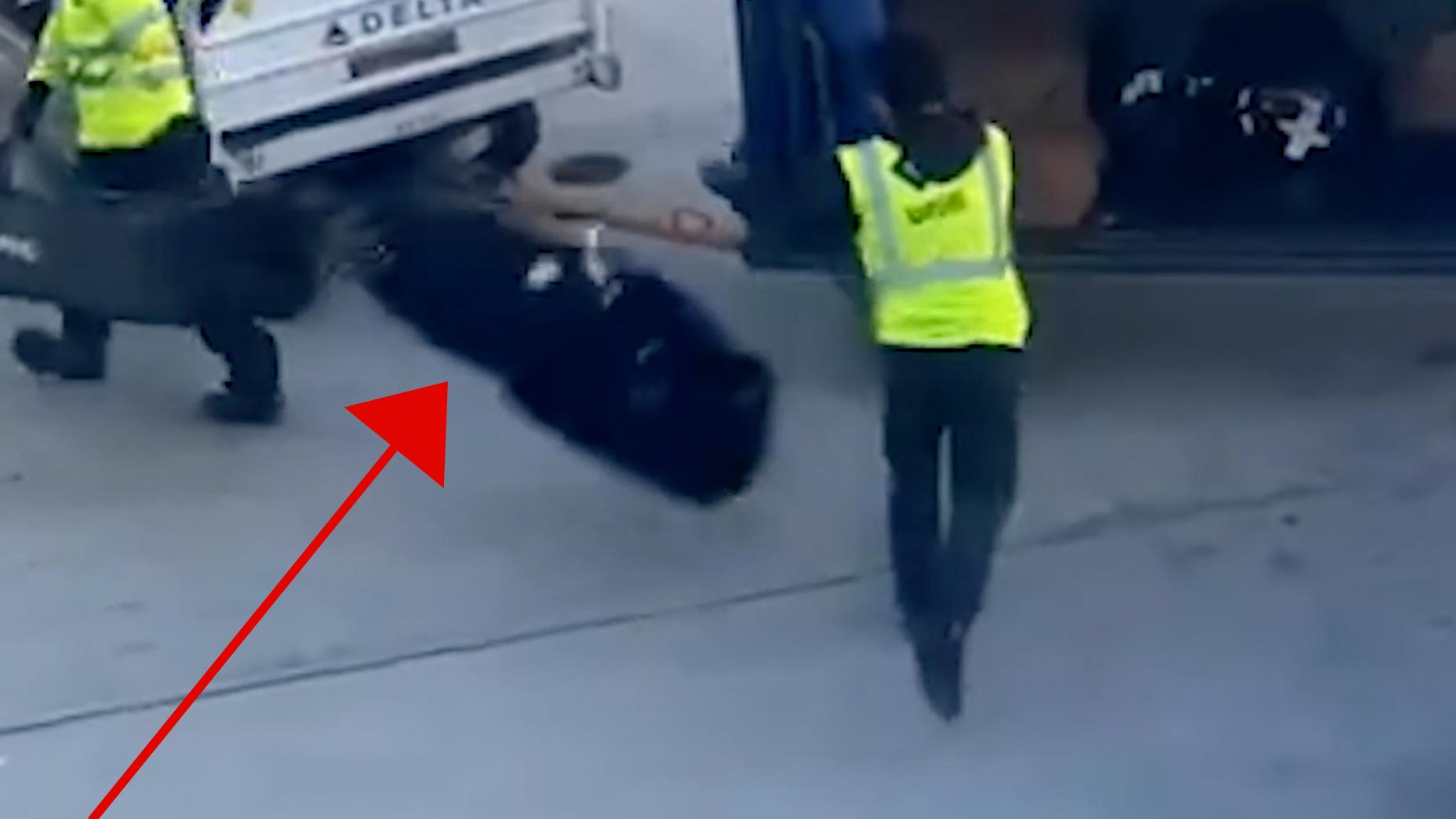 an airport worker tosses a golf bag on the ground