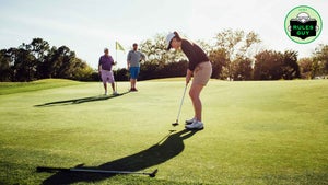 golfers putting on green