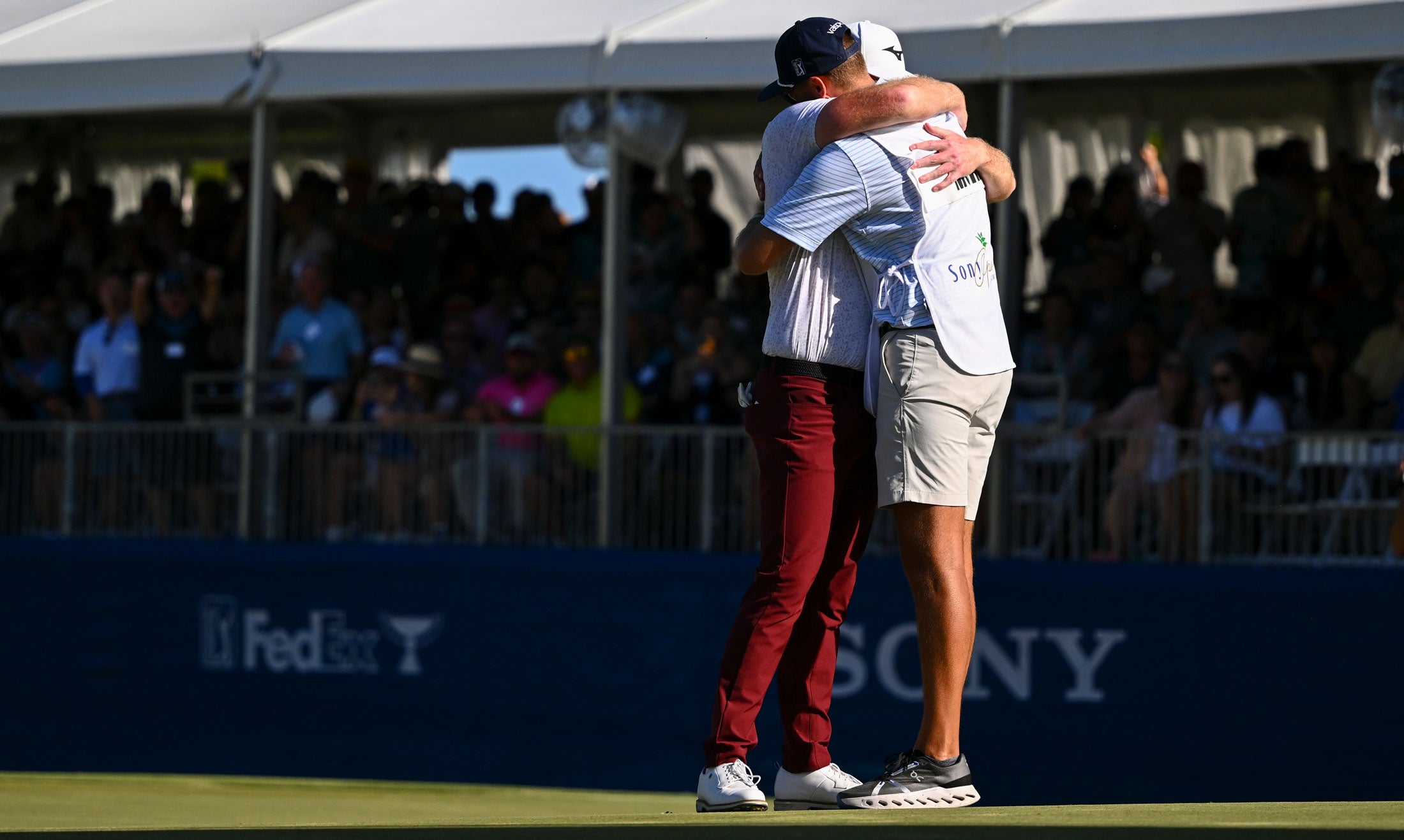 Grayson Murray hugs his caddie, Jay Green, after winning in a playoff at the 18th hole on the first playoff hole during the final round of Sony Open in Hawaii