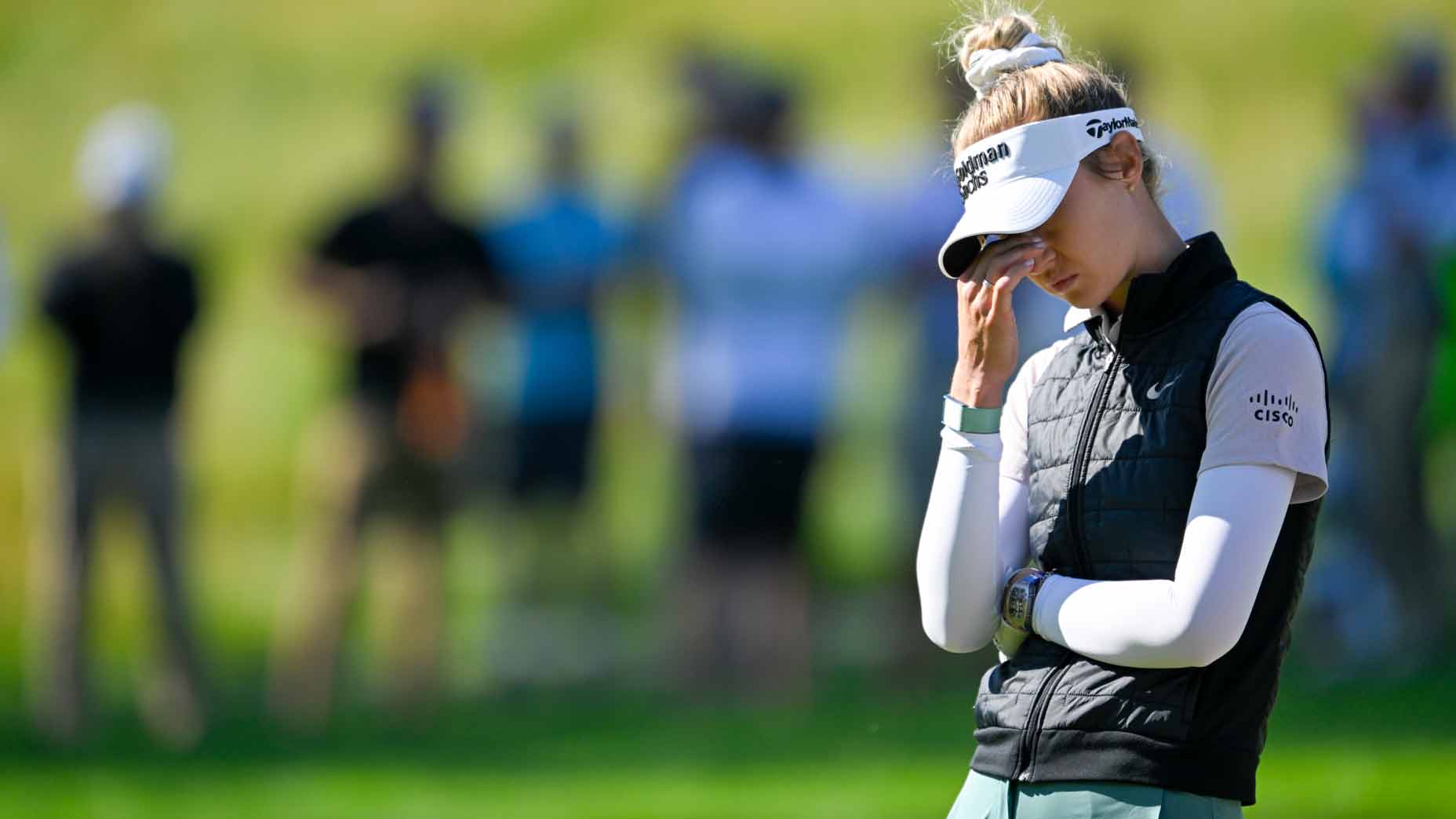 nelly korda hangs her head and rubs her eyes with her hands