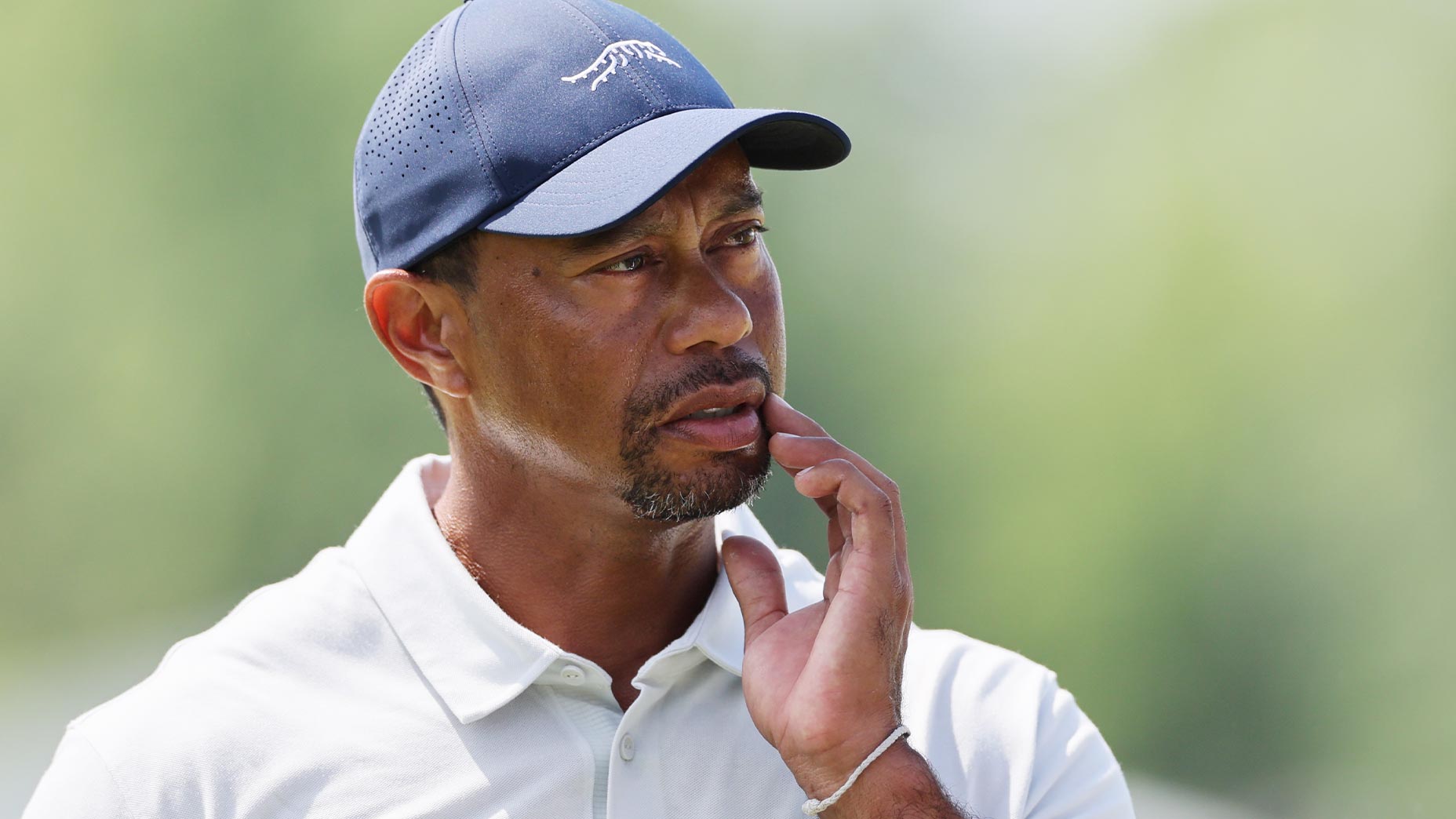 tiger woods scratches face in blue hat at the PGA championship