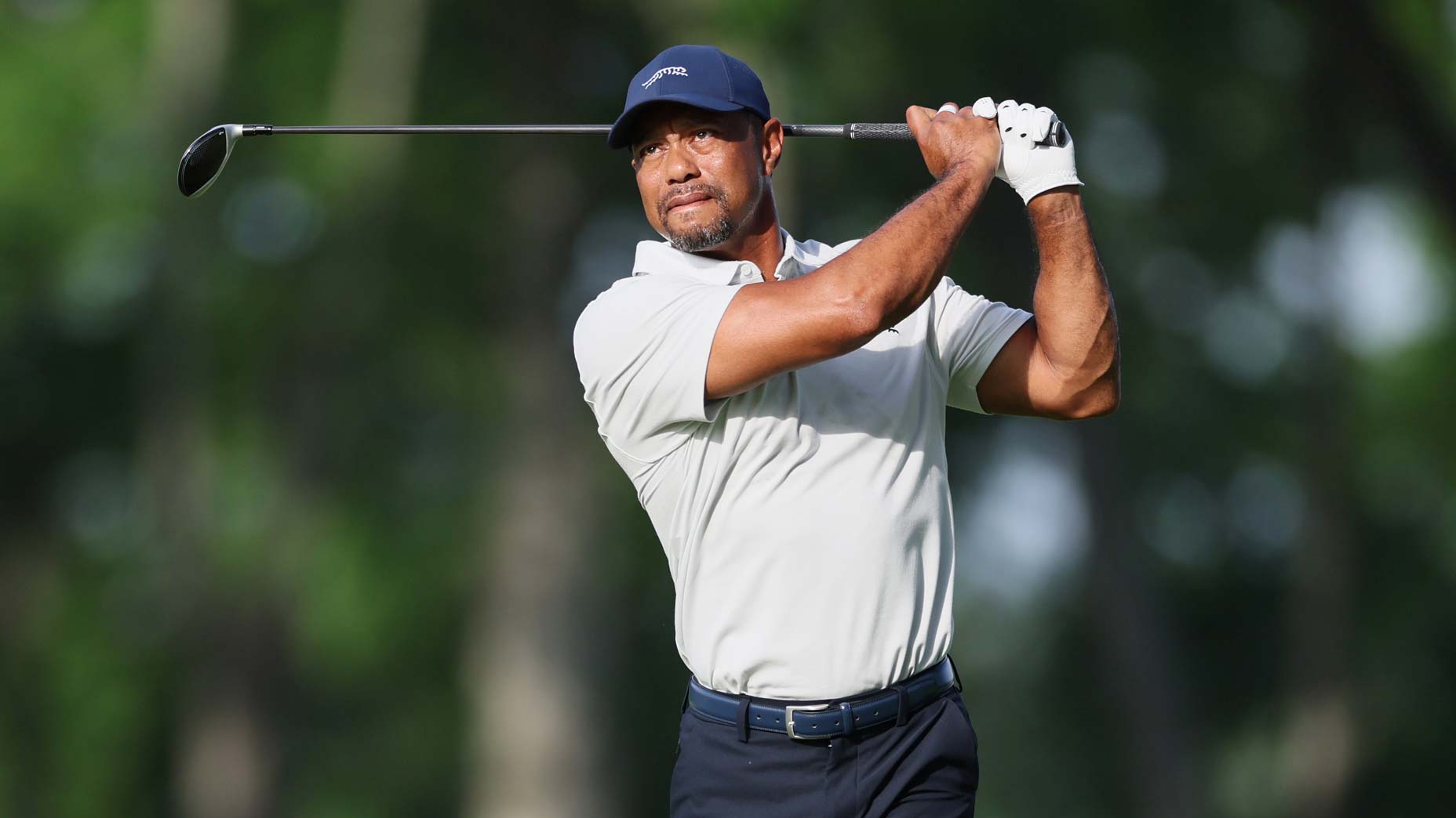 Tiger Woods in white shirt hits shot during practice at Valhalla for 2024 PGA Championship