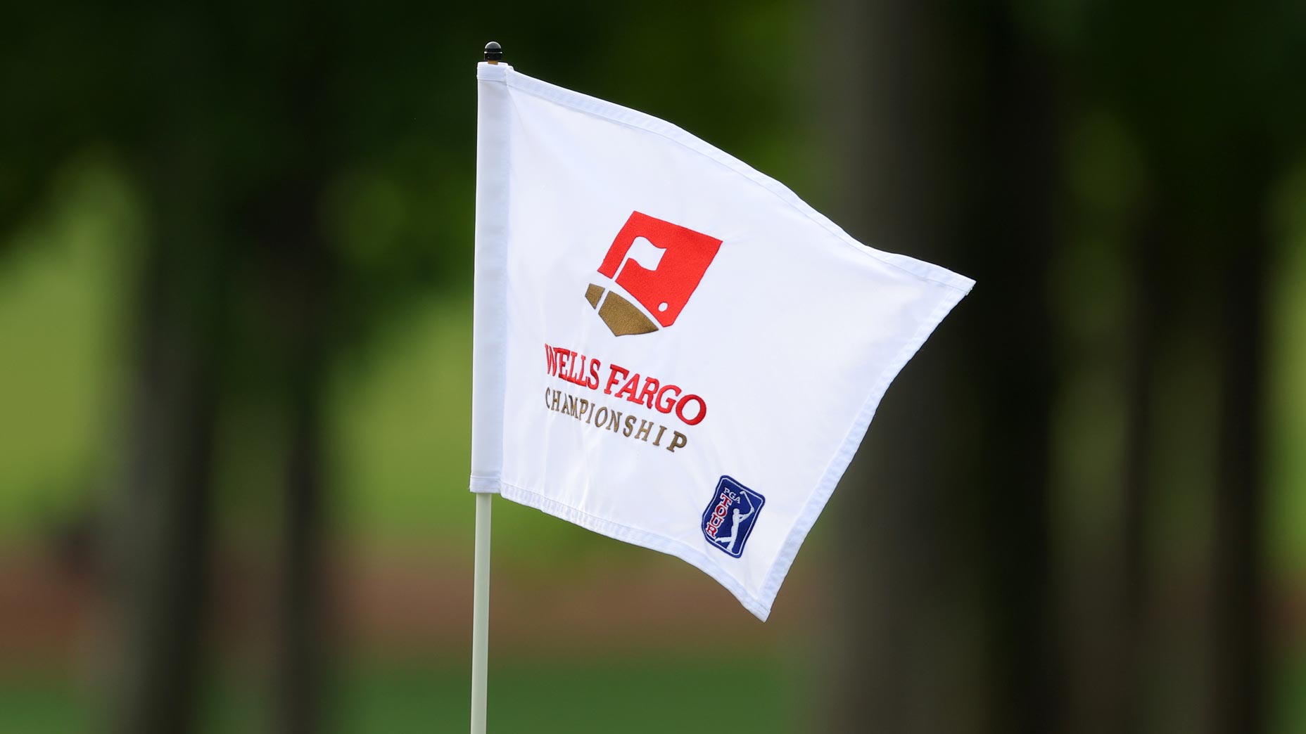 A Wells Fargo Championship pin flag flaps in the wind at Quail Hollow