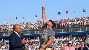 bryson dechambeau points towards the sky at the U.S. Open in flat cap