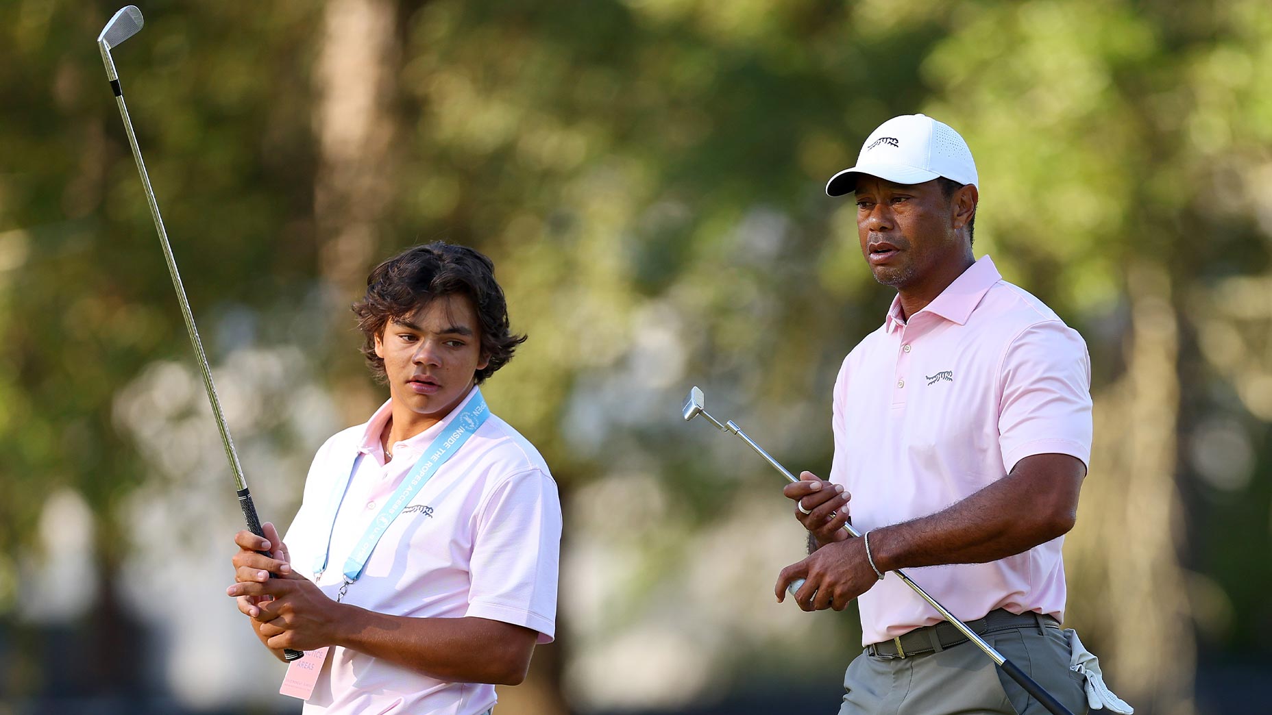 charlie woods and tiger woods stand next to each other in pink shirts