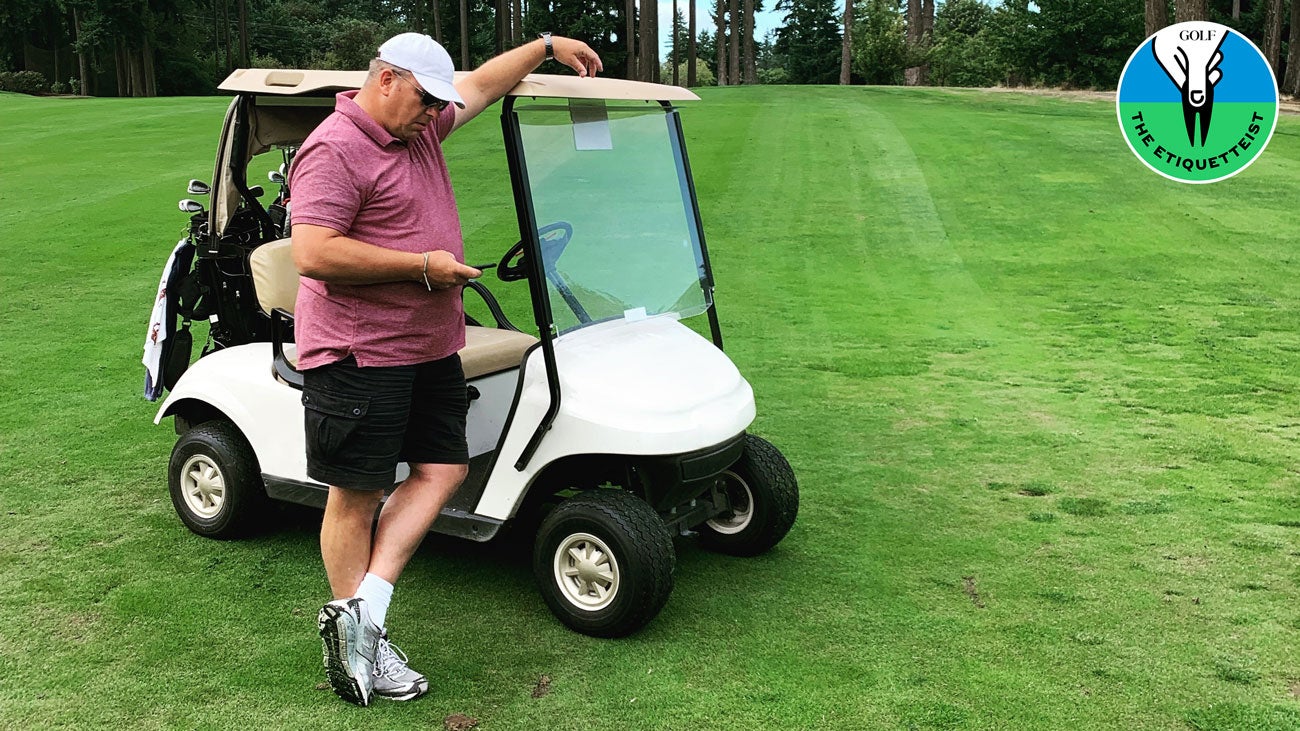 A man using a phone on the golf course