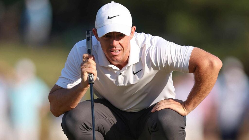 Pro golfer Rory McIlroy crouches to read a putt at 2024 U.S. Open at Pinehurst No. 2