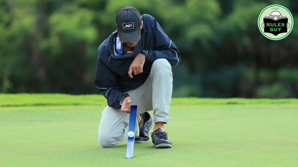 A man using a Stimpmeter on a green