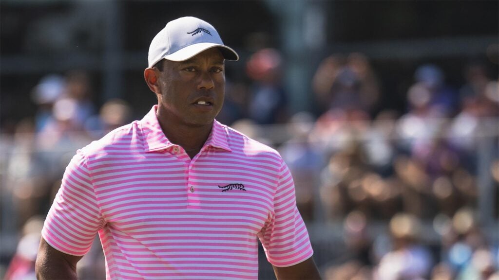 Tiger Woods stares at the U.S. Open in a pink shirt and white hat