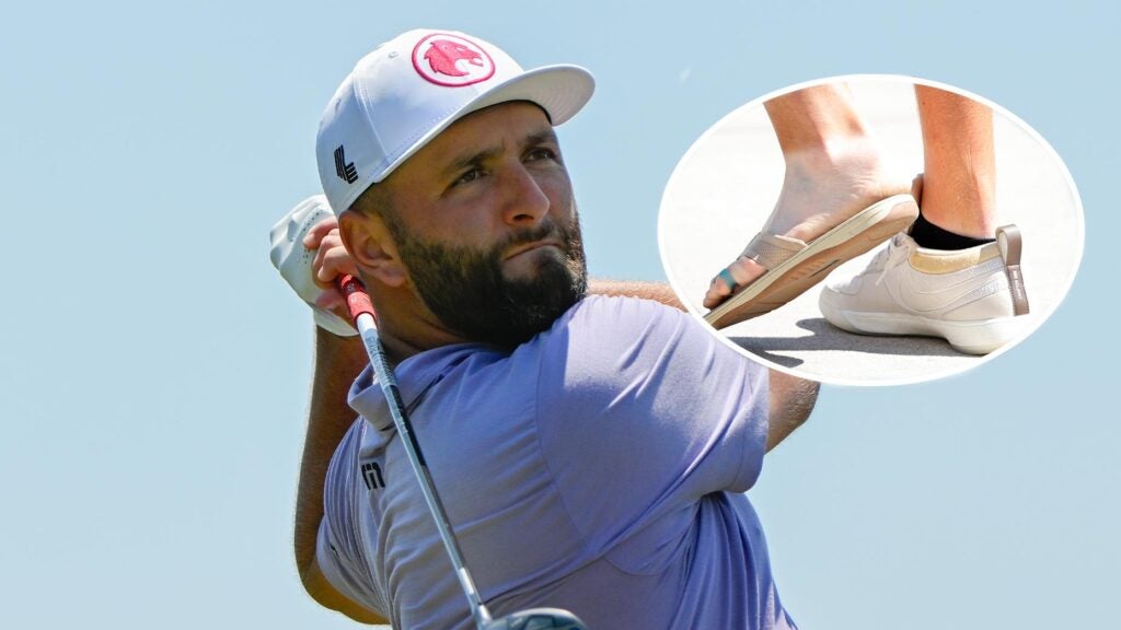 jon rahm swings a golf club while a sandal hangs in a large ellipse over his head