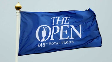 A blue 2024 Open Championship flag flaps in wind at Royal Troon