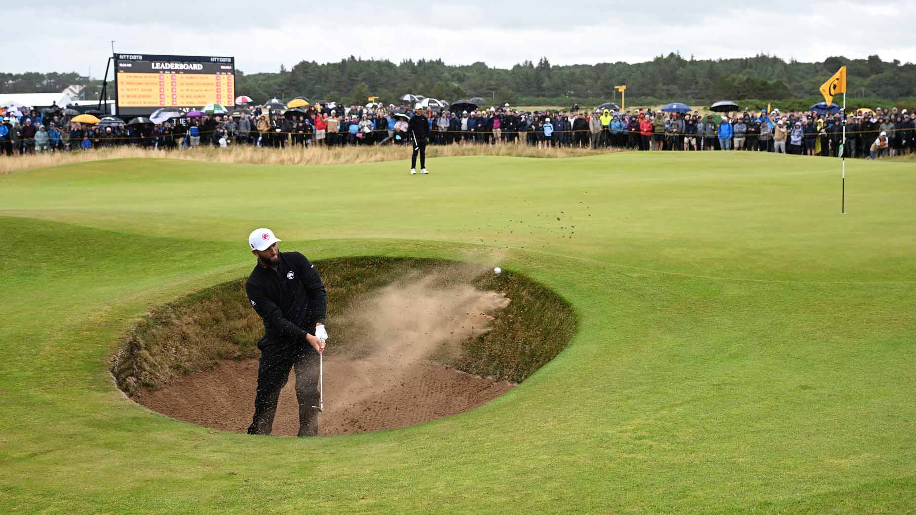 jon rahm hits out of a bunker during the first round of the 2024 open championship