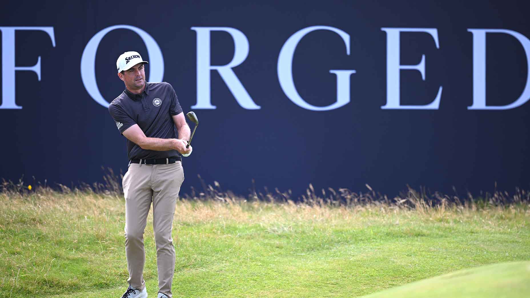 keegan bradley hits a chip in front of an Open Championship 'forged' sign