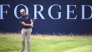 keegan bradley hits a chip in front of an Open Championship 'forged' sign