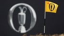 Pin flag in wind at 2024 Open Championship next to Claret Jug sign
