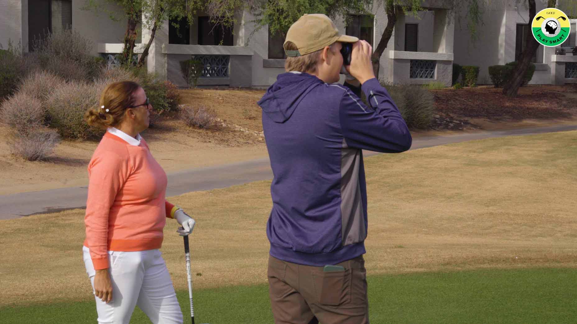 golf writer zephyr melton uses a rangefinder while christy longfield looks on