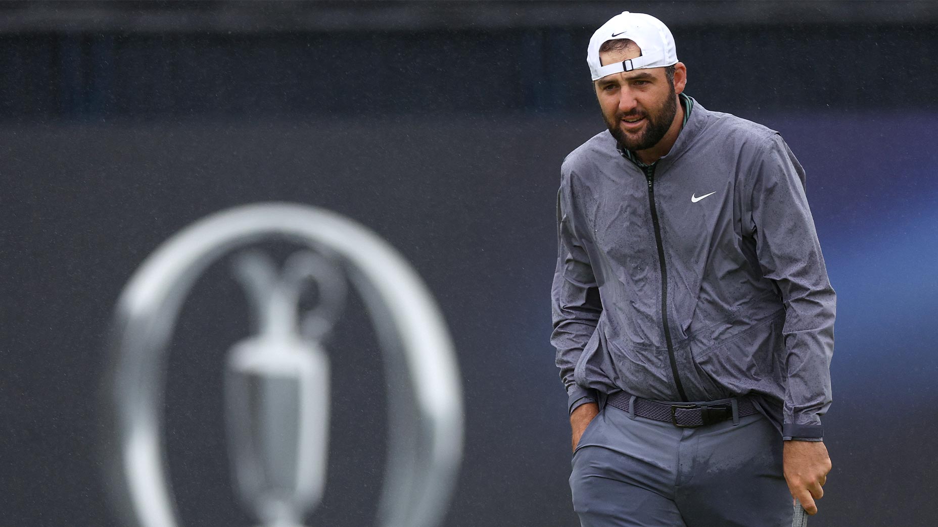 scottie scheffler grimaces in the rain in gray shirt at the Open Championship