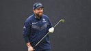 shane lowry laughs holding iron at the Open Championship in navy outfit.