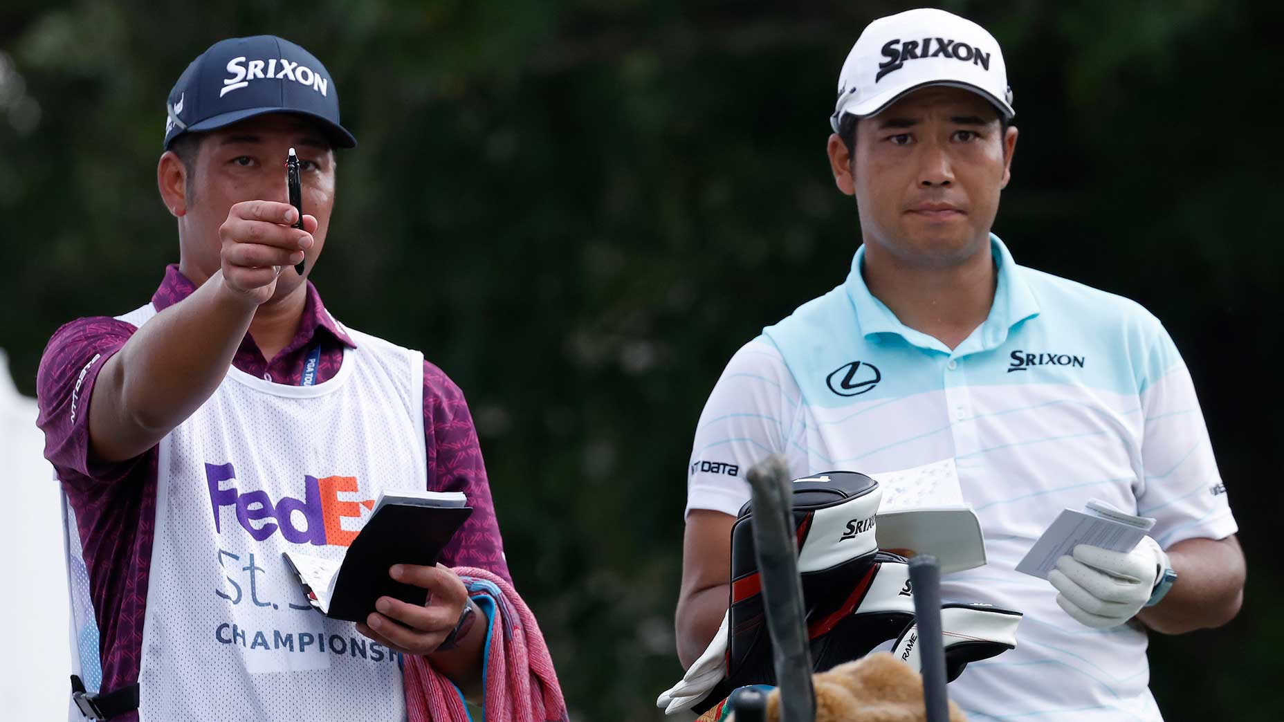 Hideki Matsuyama works with a new caddy at the FedEx St. Jude Championship.