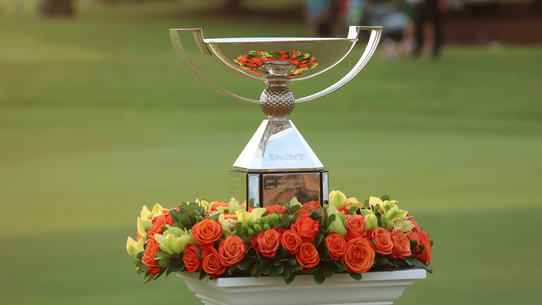 FedEx Cup trophy on pedestal with flowers at 2023 Tour Championship.