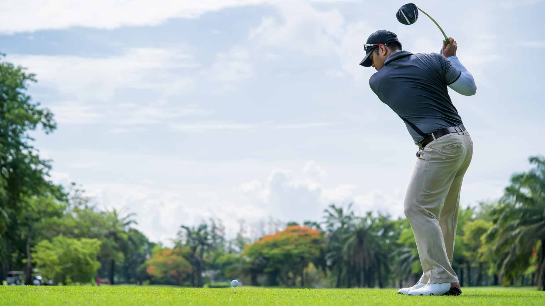 golfer swings on golf course