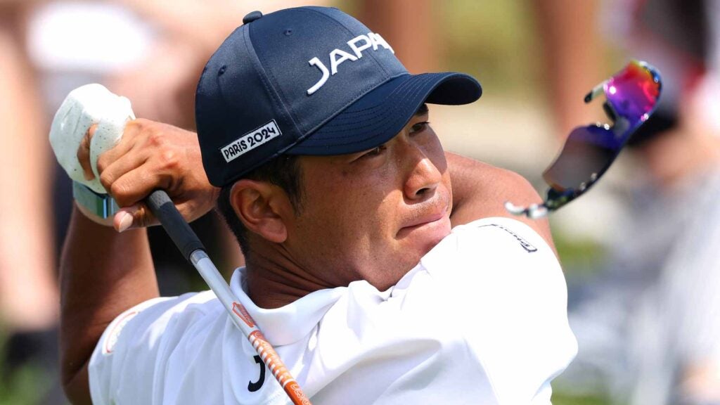 Pro golfer Hideki Matsuyama tees off on the 17th hole as his sunglasses fall from his face, during Day One of the Men's Individual Stroke Play on day six of the Olympic Games Paris 2024 at Le Golf National.