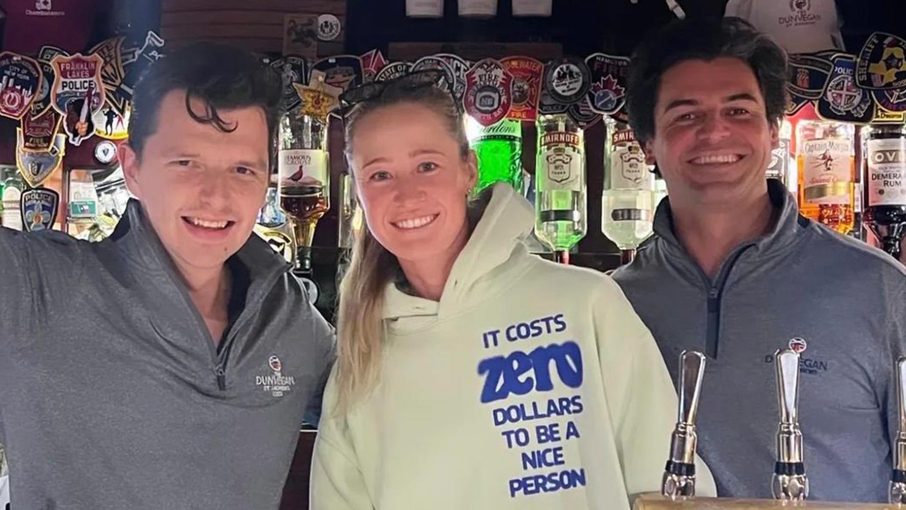 nelly korda smiles at the dunvegan bar in st andrews next to two bartenders