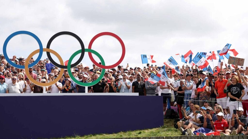 Olympic golf fans cheer in front of Olympic rings at Le Golf National
