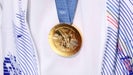 A close-up photo of gold medal hanging on Olympian at 2024 Paris Olympics.