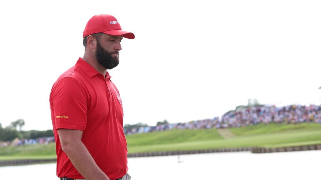 jon rahm stares sadly in a red shirt at the olympic games in paris