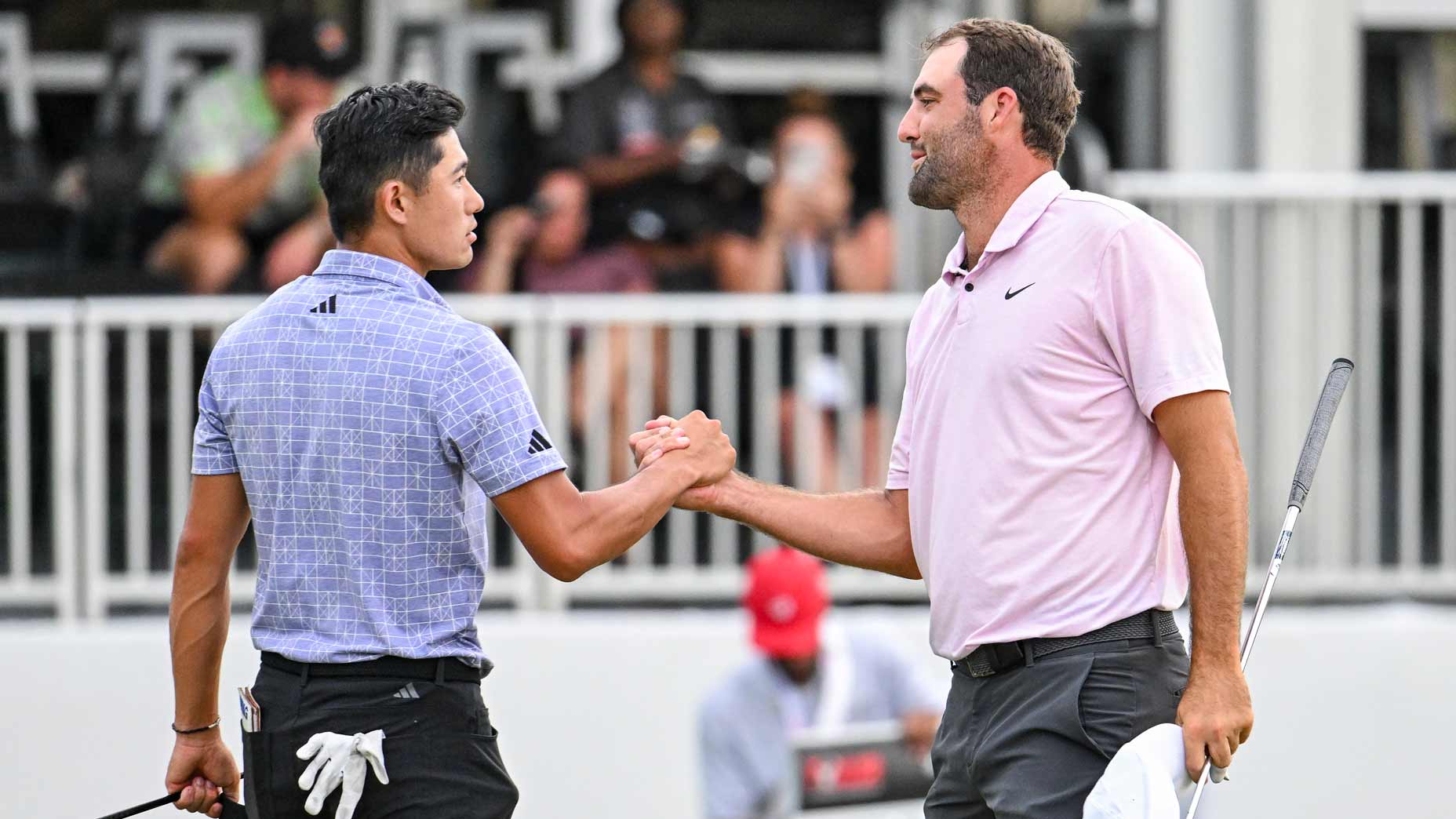 Professional golfers Scottie Scheffler and Collin Morikawa shake hands on the 18th hole after playing through inclement weather in the second round of the 2024 Tour Championship at East Lake.