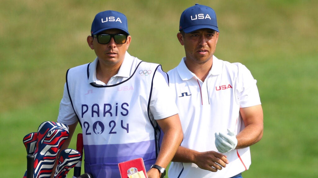 Xander Schauffele interacts with his caddie, Austin Kaiser ahead of his second shot on the third hole during Day Two of the Men's Individual Stroke Play on day seven of the 2024 Olympic Games