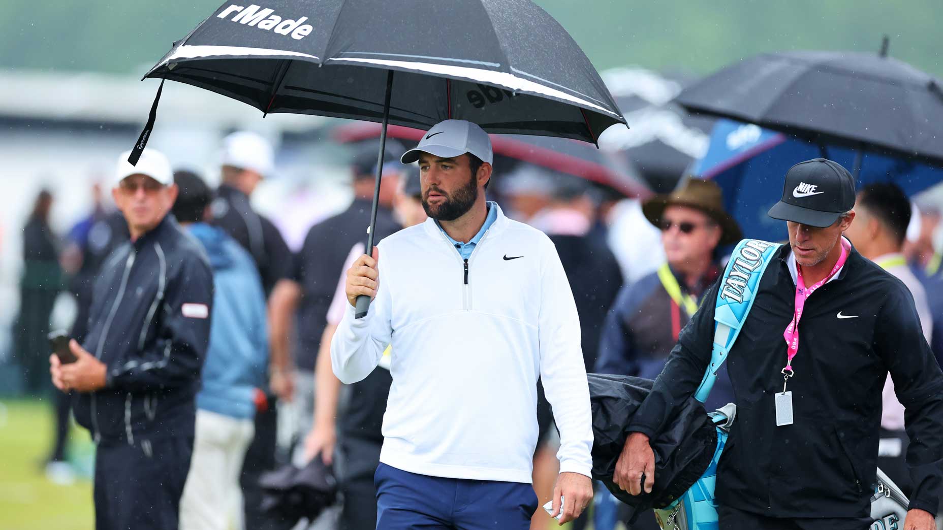 Scottie Scheffler and his caddie, Ted Scott, walk on the driving range at the PGA Championship.