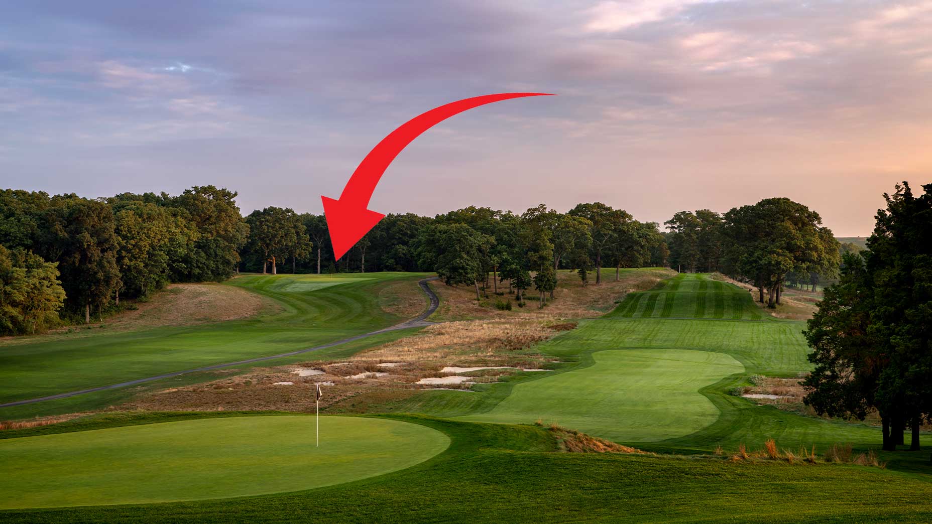 an arrow points at the first green at bethpage red at sunset