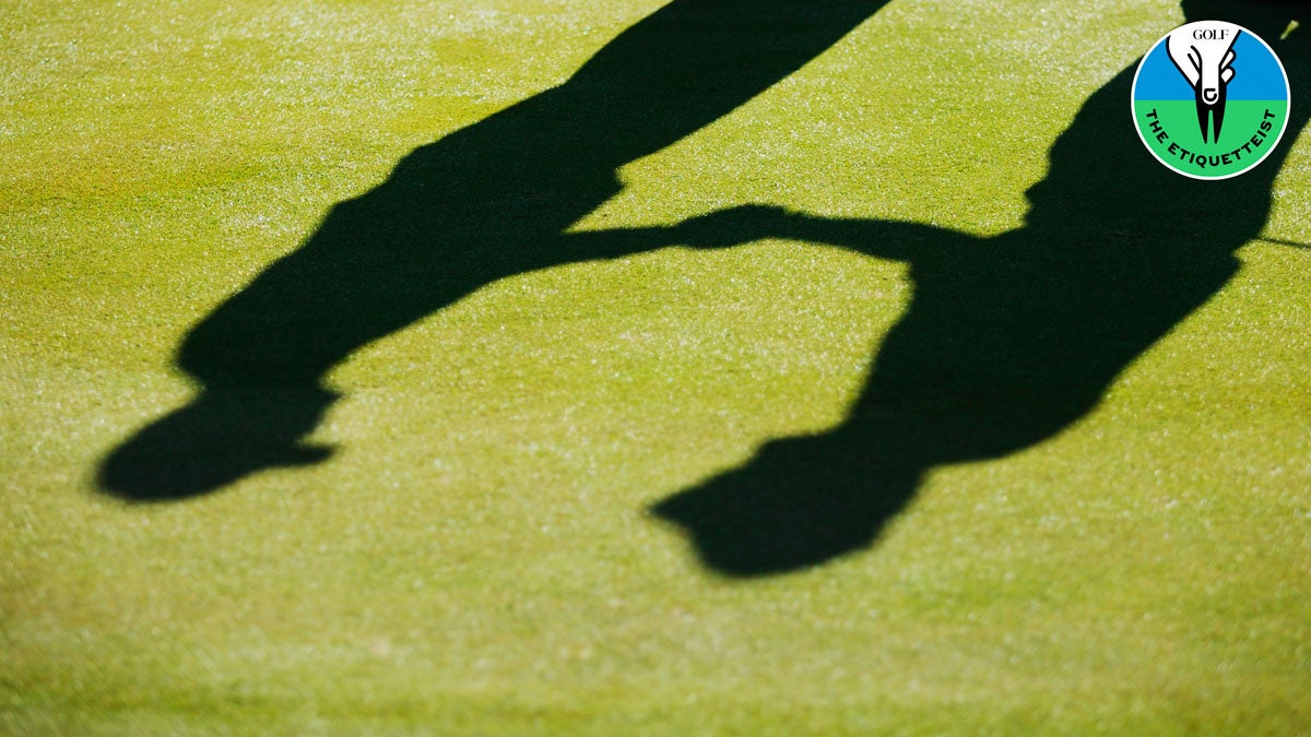 two golfers shaking hands on green