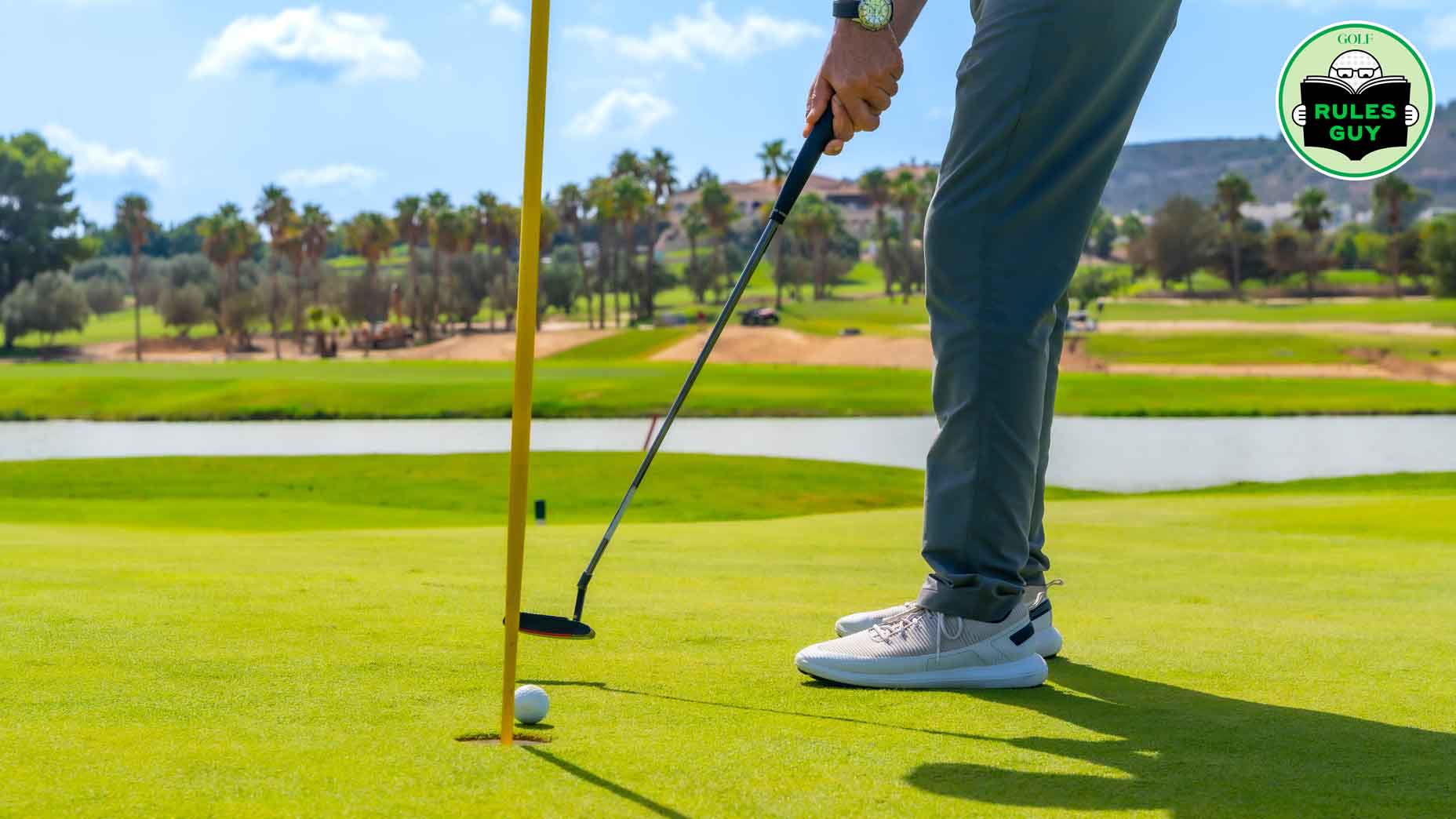 Cropped photo of the legs of a golfer hitting a ball to placed on the hole