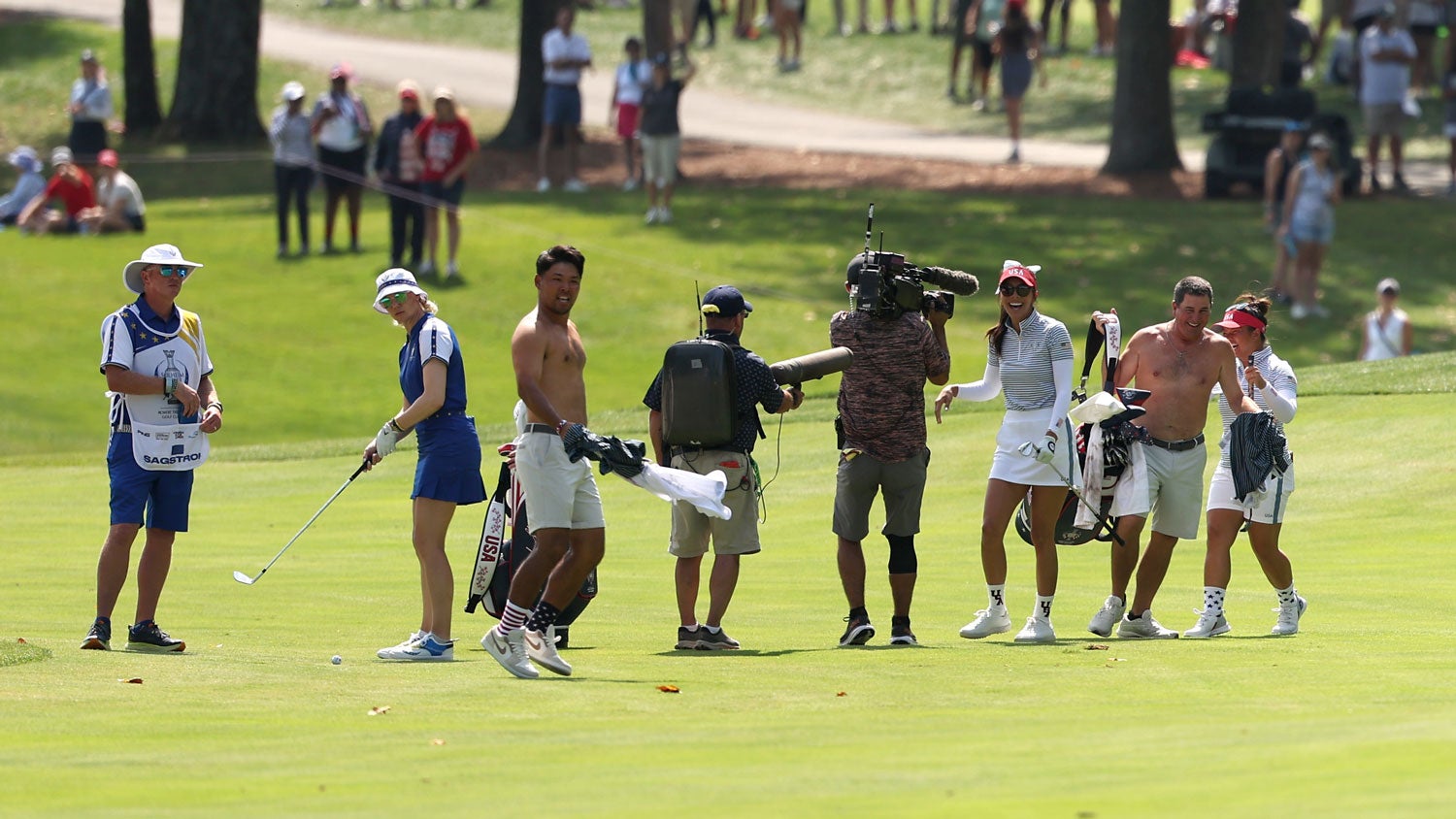 Caddies celebrate after Alison Lee hits an eagle at the Solheim Cup