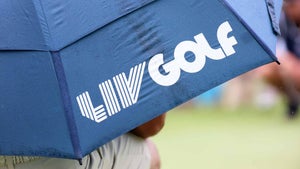 Fan holds umbrella with LIV Golf logo at the first hole during day one of the 2024 LIV Golf Greenbrier tournament at The Old White Course.